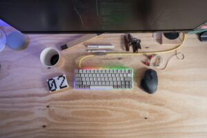 Computerarbeitsplatz mit Tastatur, Stiften und Kaffeetasse